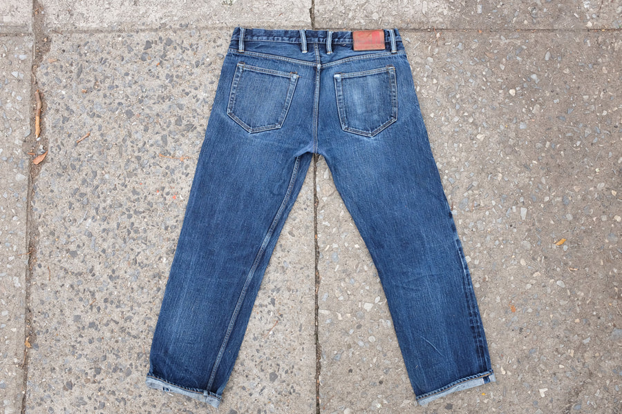 Shot of back side of well-worn denim with cuffs turned up.