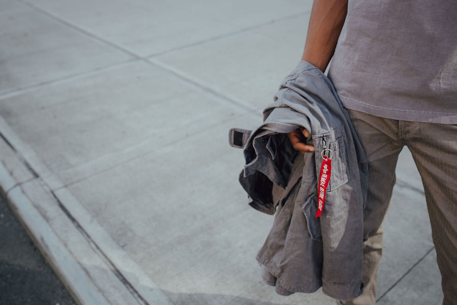 A grey fishtail parka folded over the arm of a man.