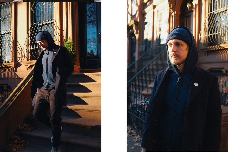 The model descends stairs from his brownstone apartment wearing the black sweatpants.