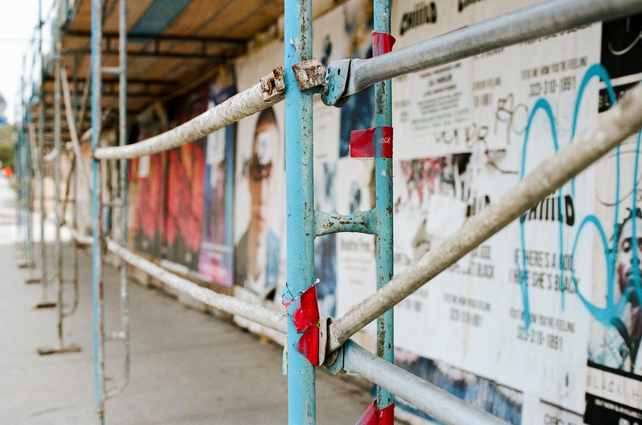 Light blue and grey scaffolding along an abandoned street.