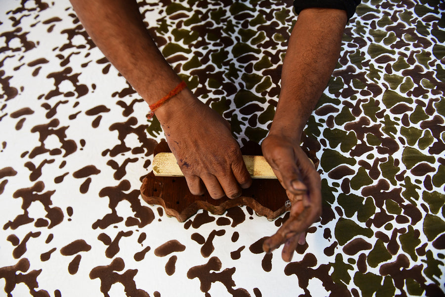 An overhead shot of fabric being printed by hand.
