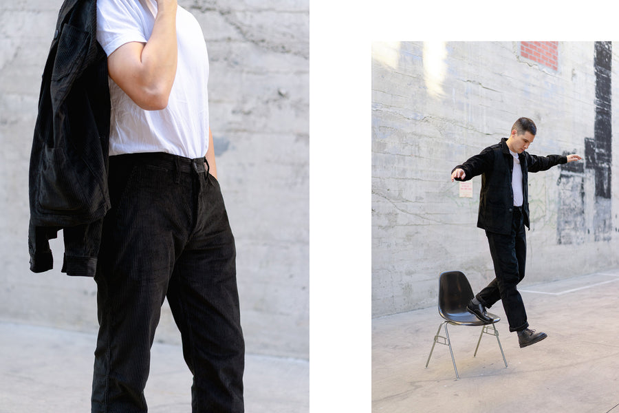 A man models a white tee and a black corduroy suit.