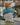 A lady takes off the blue sweater.