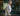 A blurry image of a lady in a yellow flannel walking down the street.