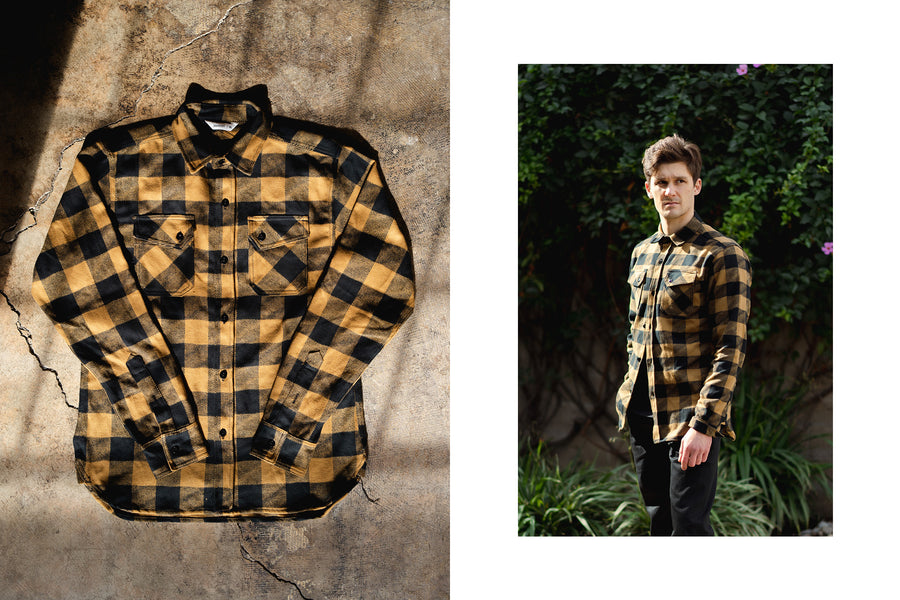 A young man wears the mustard and black colorway of the drunk check crosscut flannel.