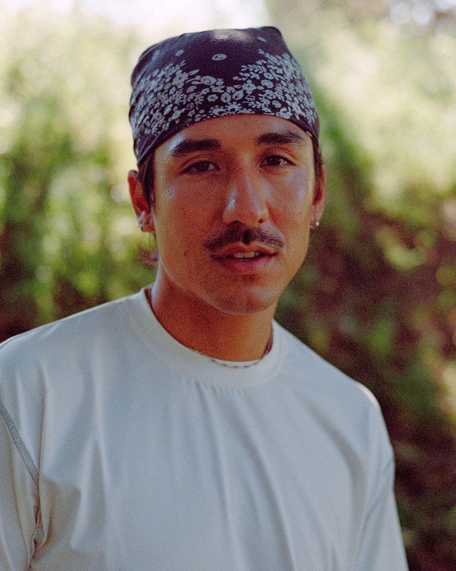 A portrait of a man with a mustache wearing a bandana.