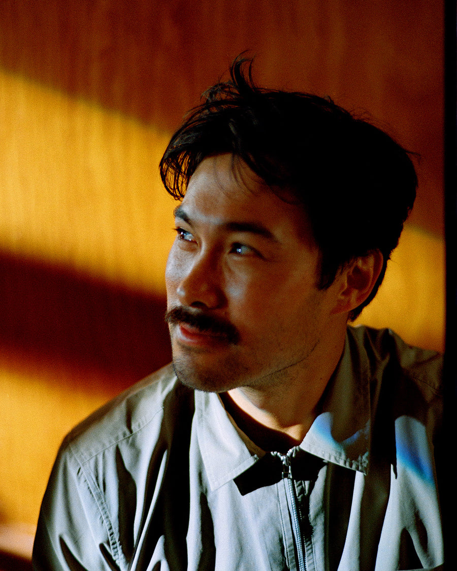 A portrait of a man with a mustache in a green shirt.