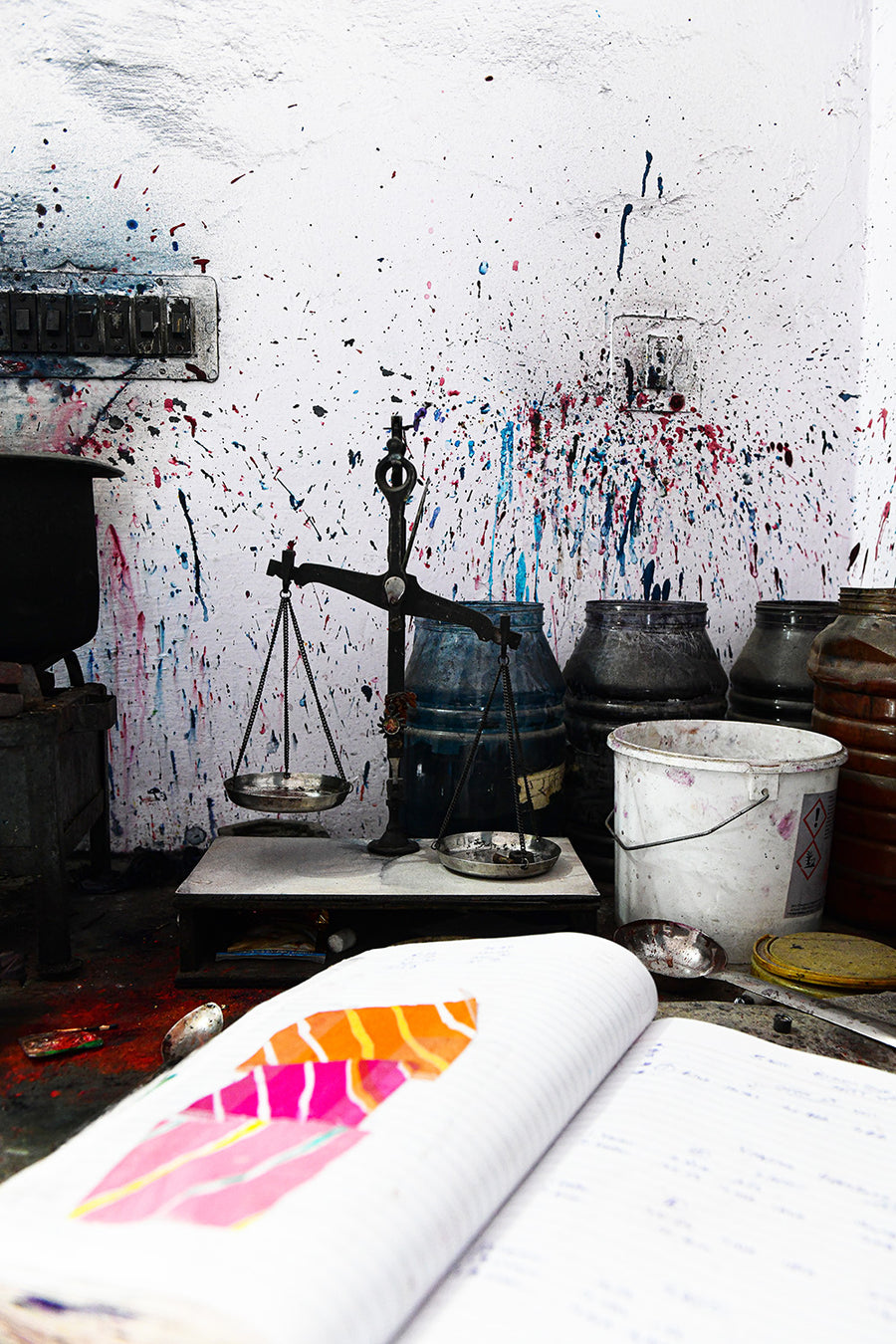 Brightly colored inks splattered against a wall.