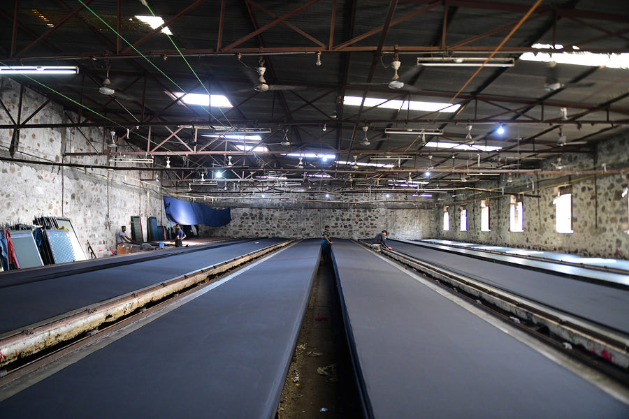 A cavernous room with fabric stretched on tables all the way across.