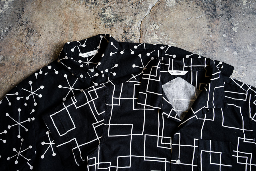 Two 3sixteen shirts lay on a concrete floor