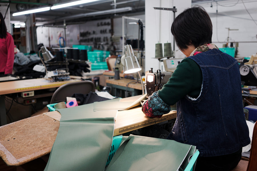 A sewer puts together legs of selvedge chinos.