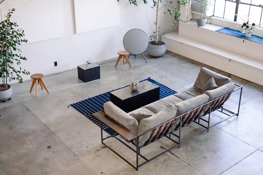 The rug sits in front of a large grey couch.