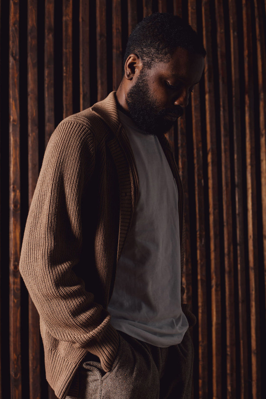 A man wears a brown sweater.