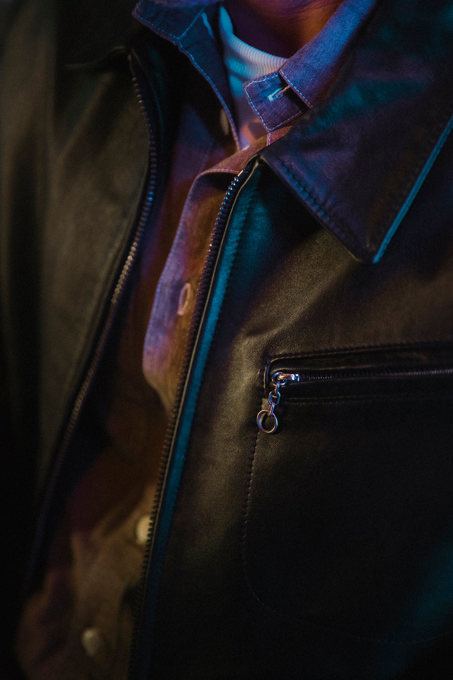 A closeup detail shot of black leather texture on a jacket.