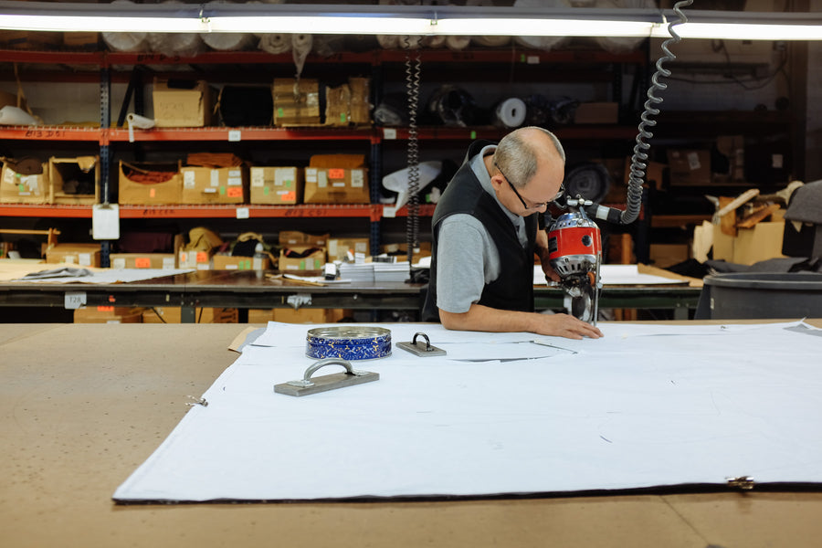 A skilled worker at the Schott factory cuts fabric with a machine.
