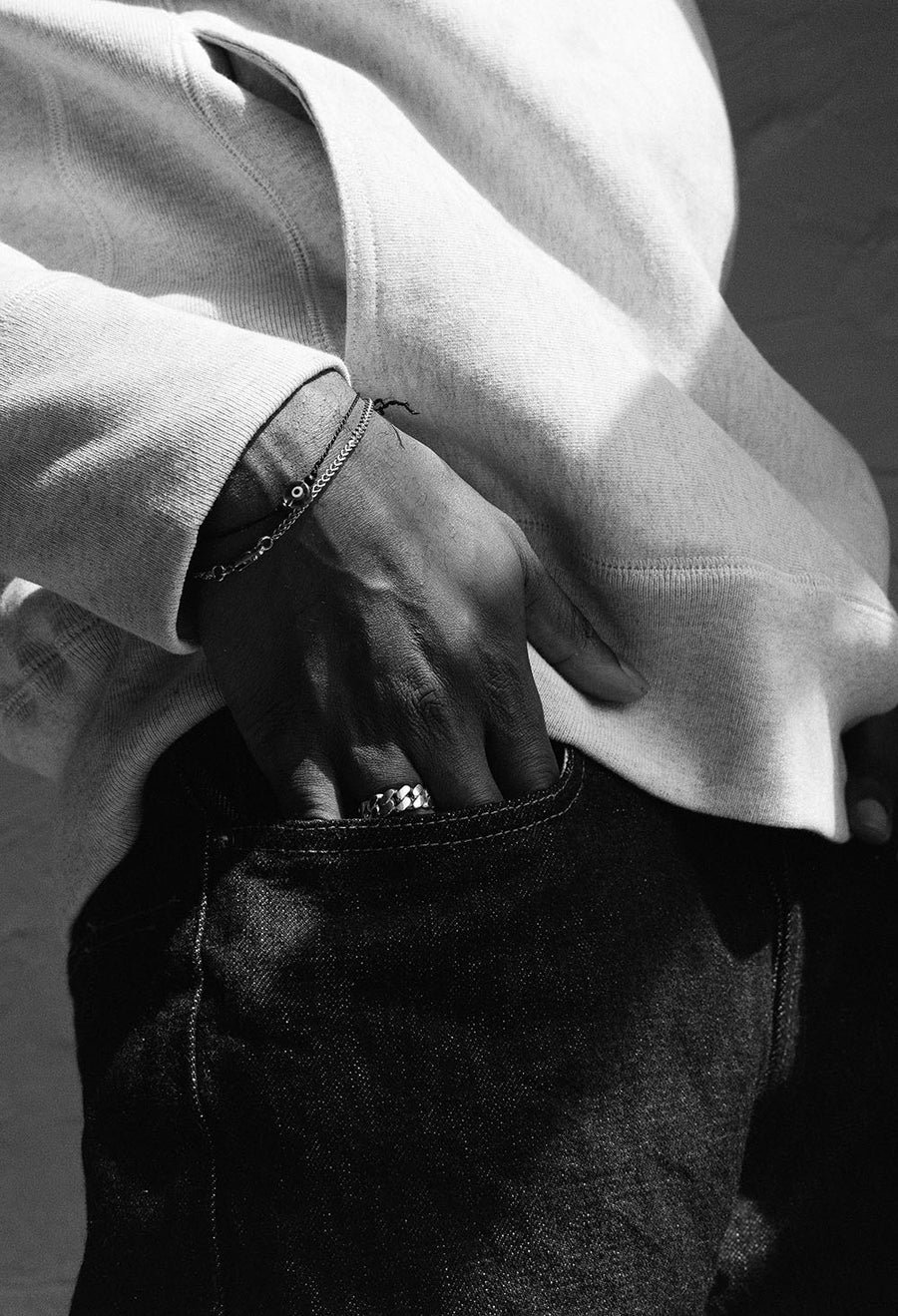 A closeup of a hand half-entered into a denim jean pocket.