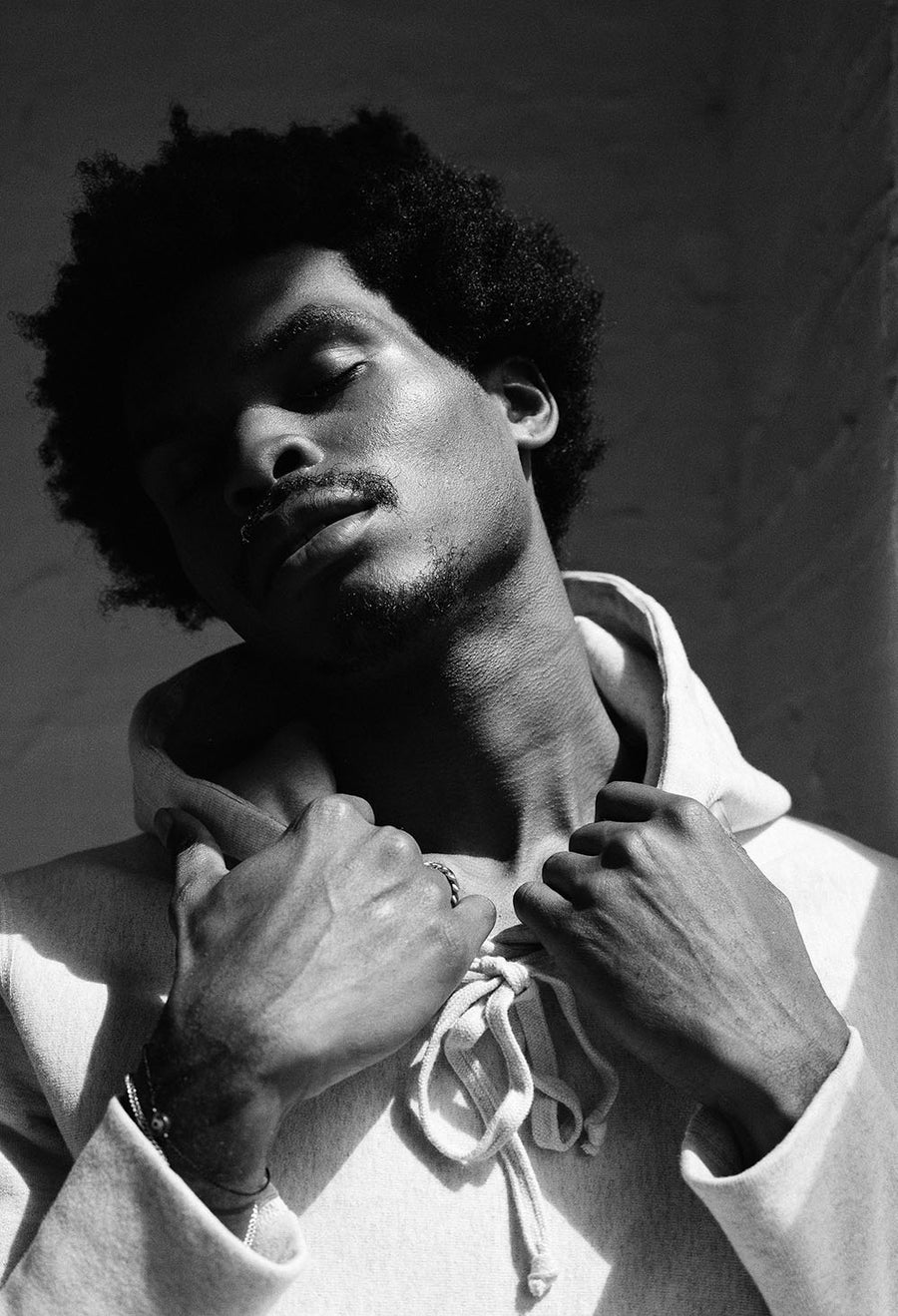 Sunlight streams onto the model's face as he closes his eyes blissfully.