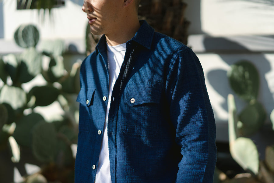 A man wears an indigo blue shirt.