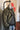 A mannequin sporting a field jacket, a sweater and some faded jeans.