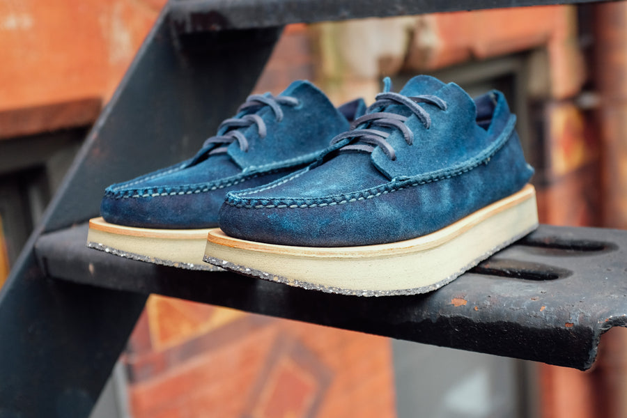 A low front oblique shot of the indigo moccasins sitting on the fire escape.