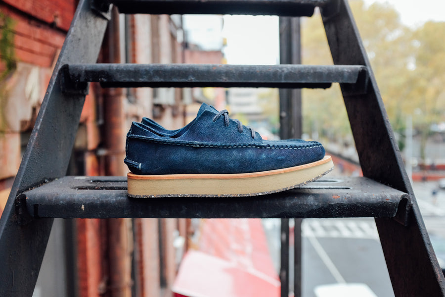 A pair of indigo moccasins sit on a fire escape.